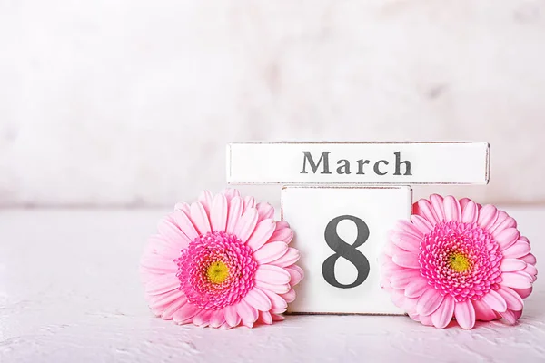 Kalender med datum för Internationella kvinnodagen och blommor på ljust bord — Stockfoto