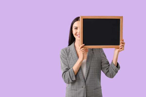 Female teacher with chalkboard on color background — Stock Photo, Image