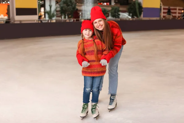 Young mother with little daughter on skating rink — Stock Photo, Image