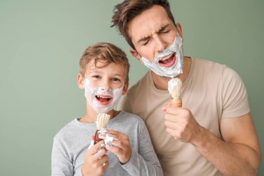 Komik baba ve küçük oğlu renk geçmişlerine karşı traş oluyorlar.