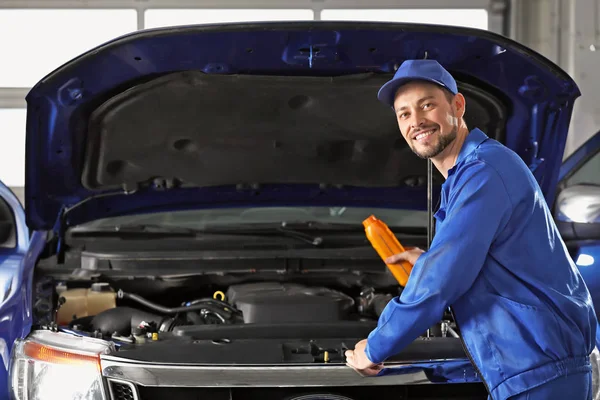 Masculino mecânico recarga de óleo de carro no centro de serviço — Fotografia de Stock