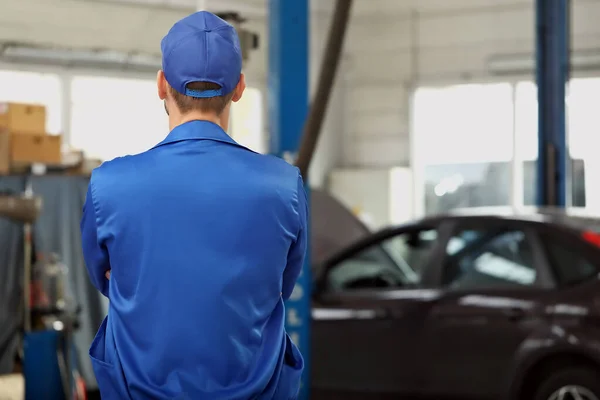 Mecánico masculino en el centro de servicio del coche, vista trasera — Foto de Stock