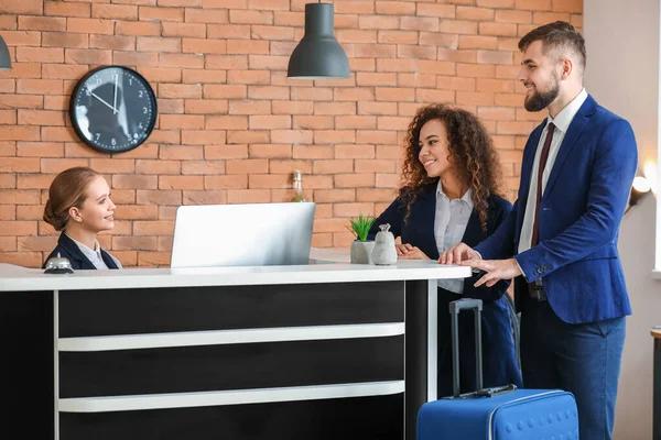 Young female receptionist working with guests in hotel — 스톡 사진