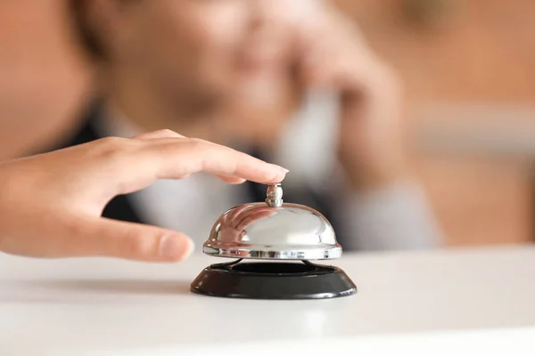 Woman ringing service bell on reception desk in hotel, closeup — Stock Photo, Image