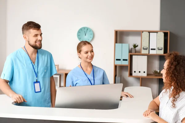 Male and female receptionists working at desk in clinic — Stock Photo, Image