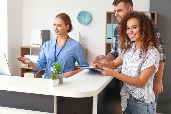 Young woman near reception desk in clinic — Stock Photo, Image