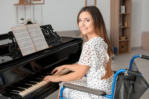 Young woman in wheelchair playing grand piano at home — Stock Photo, Image