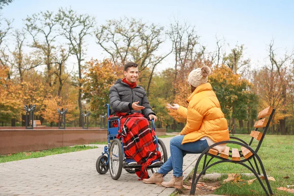 Ένας ανάπηρος νεαρός άνδρας και η σύζυγός του στο πάρκο του φθινοπώρου — Φωτογραφία Αρχείου