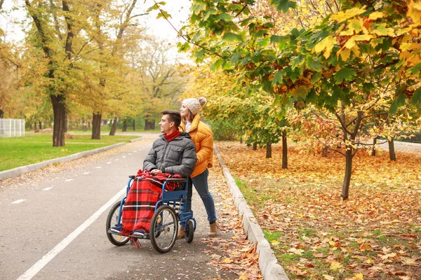 Joven discapacitado y su esposa en el parque de otoño —  Fotos de Stock