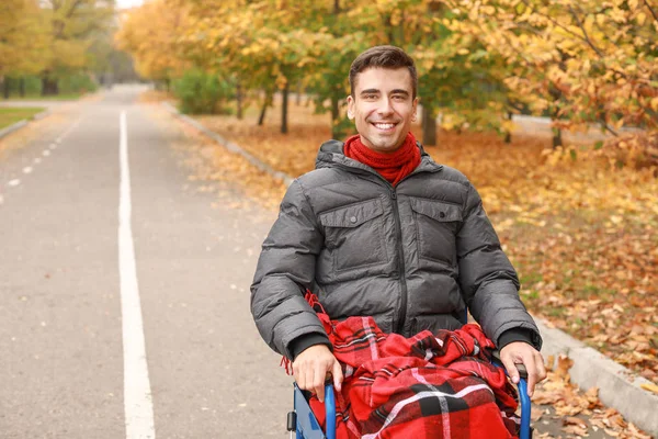 Handicapped young man in autumn park — Stock Photo, Image