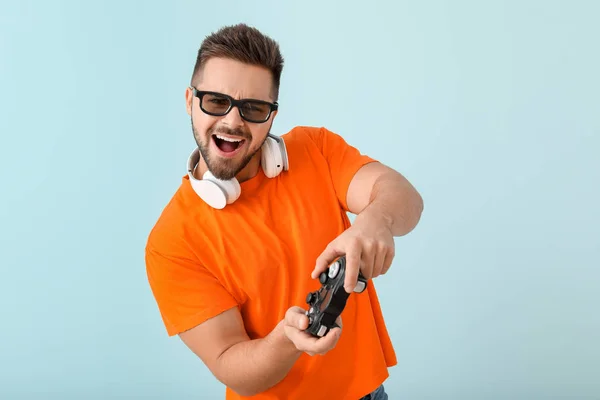 Молодой человек играет в видеоигры на цветном фоне — стоковое фото