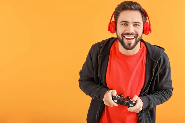 Mann spielt Videospiel auf farbigem Hintergrund — Stockfoto