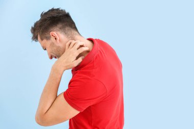 Renkli arka planda alerjik genç adam kaşınıyor