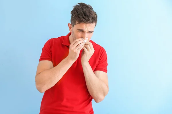 Young man suffering from allergy on color background — Stock Photo, Image