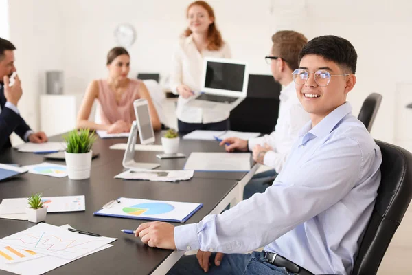 Jonge Aziatische zakenman tijdens de vergadering in functie — Stockfoto