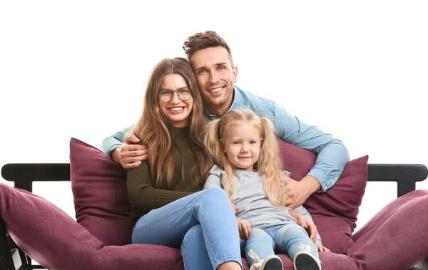 Glückliche junge Familie sitzt auf Sofa vor weißem Hintergrund — Stockfoto
