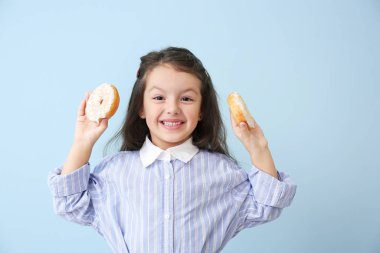 Renkli donutları olan komik küçük bir kız.