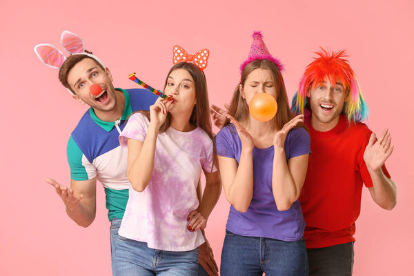People in funny disguise on color background. April fools' day celebration Stock Photo