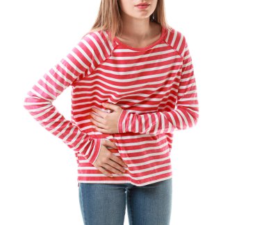 Beyaz arka planda karın ağrısı çeken genç bir kadın.