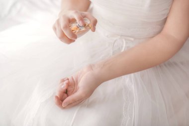 Evde parfüm şişesi ile güzel genç gelin, closeup