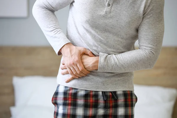 Young man suffering from abdominal pain at home — Stock Photo, Image