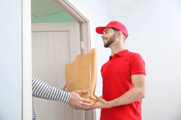 Man receiving order from courier of food delivery company — 스톡 사진