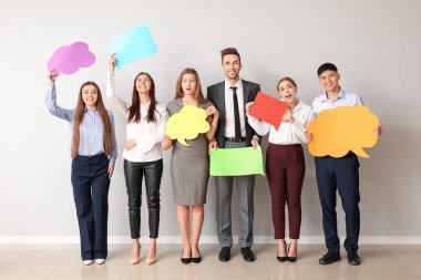 Işık duvarının yanında boş konuşma baloncukları olan bir grup iş adamı