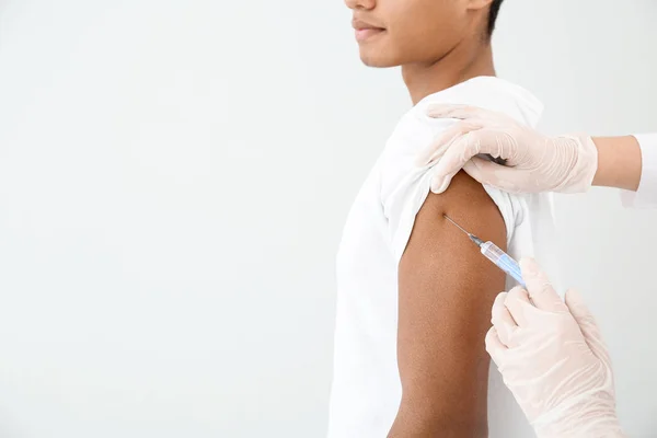 Läkare vaccinera tonåring pojke på vit bakgrund — Stockfoto