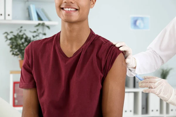 Läkare vaccinerar tonårspojken på kliniken — Stockfoto
