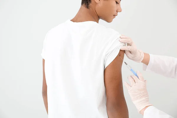 Läkare vaccinera tonåring pojke på vit bakgrund — Stockfoto