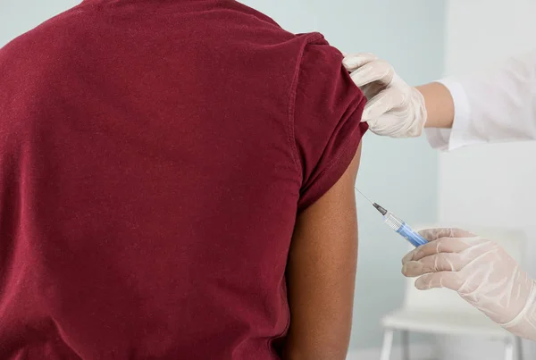 Läkare vaccinerar tonårspojke på kliniken, närbild — Stockfoto