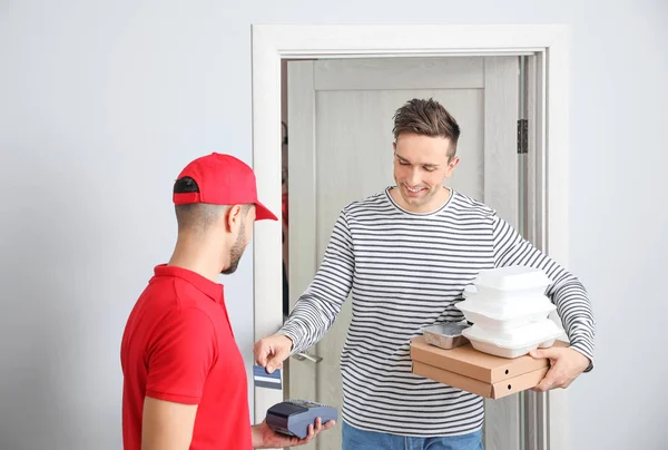 Man paying courier for food delivery via terminal — Stock Photo, Image