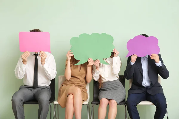 Group of business people with blank speech bubbles on color background