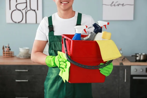 Ásia zelador com limpeza suprimentos no cozinha — Fotografia de Stock