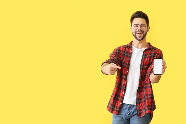 Jovem feliz com telefone celular no fundo de cor — Fotografia de Stock