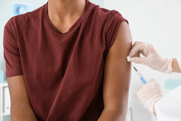 Läkare vaccinerar tonårspojke på kliniken, närbild — Stockfoto