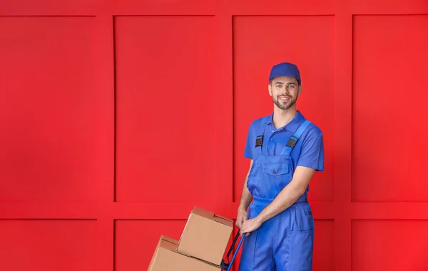 Entrega hombre con cajas en el fondo de color —  Fotos de Stock