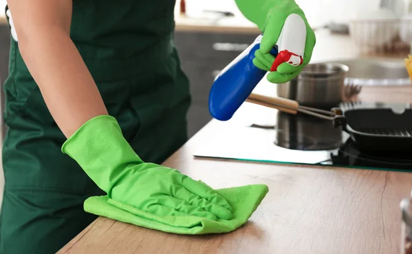 Male janitor cleaning table in kitchen — Stock Photo, Image