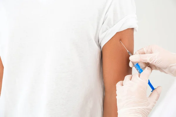 Doctor vaccineren tiener jongen op witte achtergrond, close-up — Stockfoto