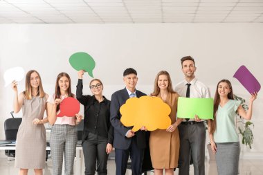 Ofisinde boş konuşma baloncukları olan bir grup iş adamı.