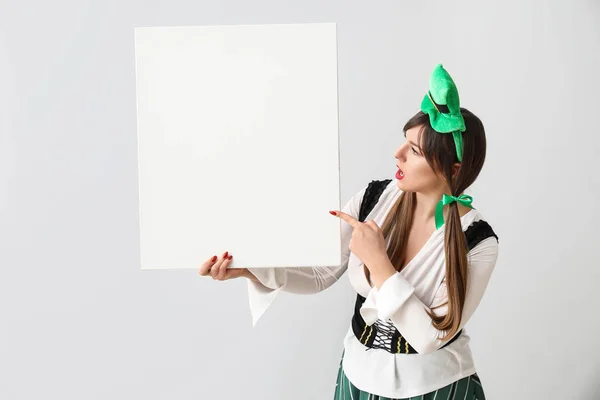 Funny young woman with blank poster on light background. St. Patrick's Day celebration — 스톡 사진