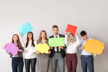 Işık arka planında boş konuşma baloncukları olan bir grup iş adamı