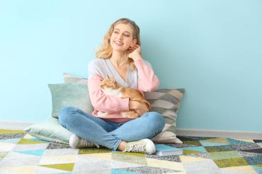 Evinde sevimli kedisi olan güzel genç bir kadın.