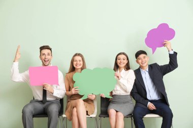 Renk arkaplanı üzerinde boş konuşma baloncukları olan bir grup iş adamı