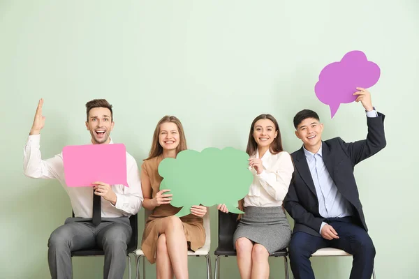 Group of business people with blank speech bubbles on color background