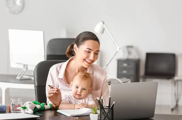 Working mother with her baby in office