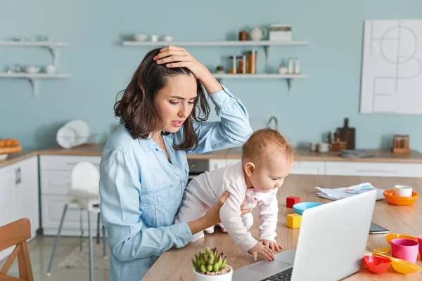Stressed mother with her baby working at home — Stock Photo, Image