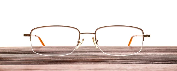 Lunettes élégantes sur table en bois sur fond blanc — Photo