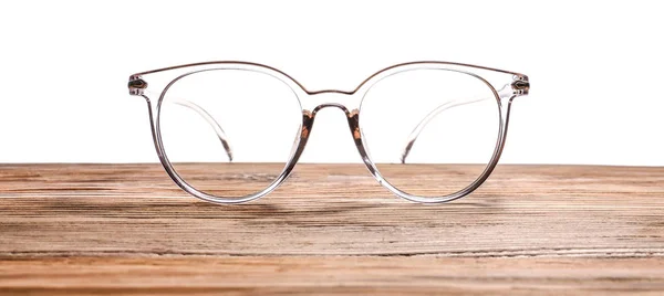 Elegantes gafas graduadas sobre mesa de madera sobre fondo blanco — Foto de Stock