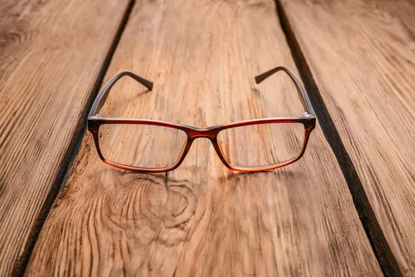 Elegantes gafas graduadas sobre mesa de madera — Foto de Stock